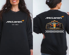 a woman wearing a black sweatshirt with a racing car on it