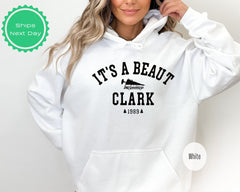 a woman wearing a white hoodie that says it&#39;s a beauty clark