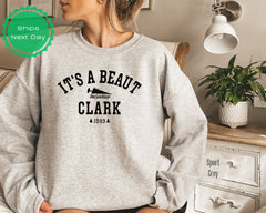 a woman wearing a sweatshirt that says it&#39;s a beauty clark