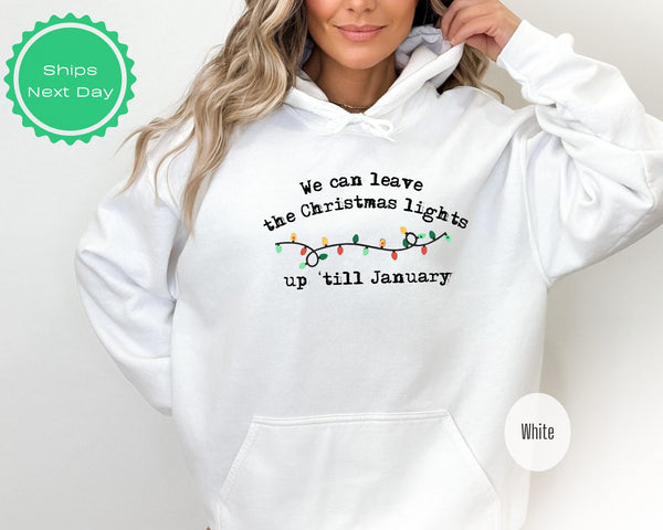 a woman wearing a white christmas sweatshirt with lights on it